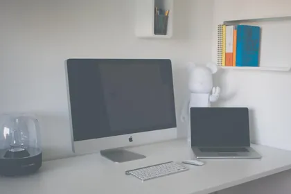 A desktop computer and a laptop on a white desk